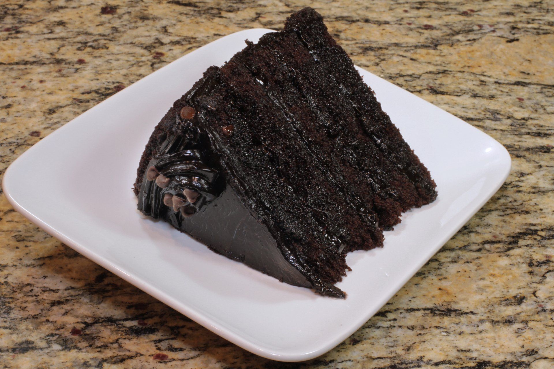 A slice of chocolate cake on a white plate