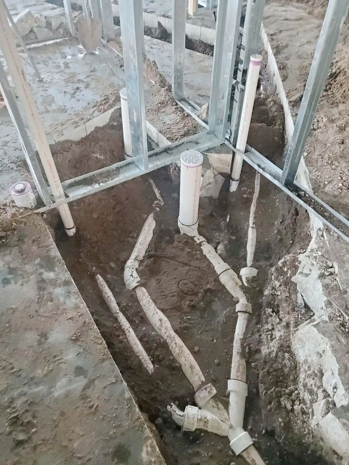 A bunch of pipes are being installed in a hole in the ground.