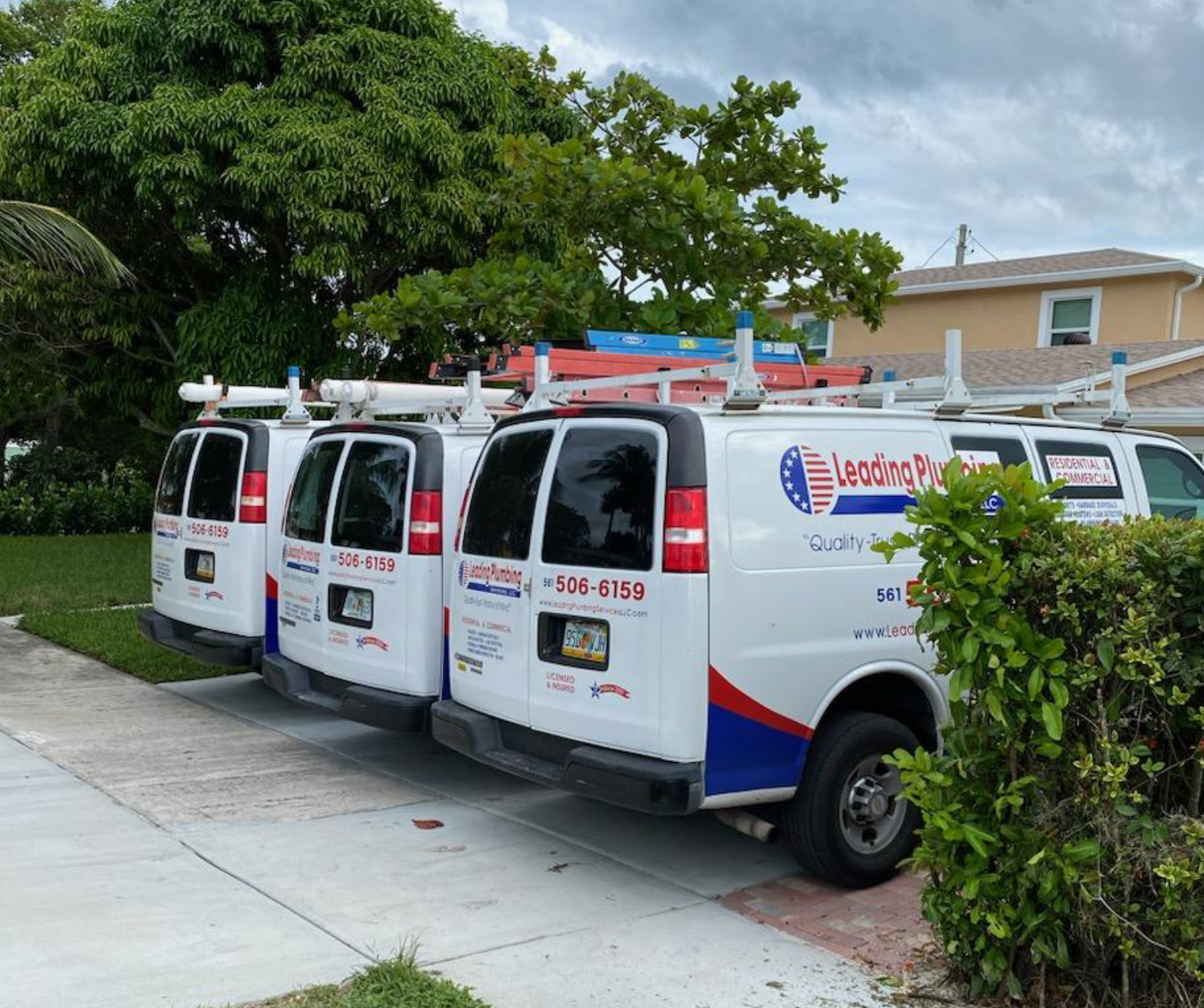 A row of vans are parked on the side of the road.