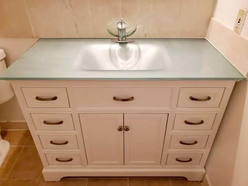 A bathroom vanity with a sink and a toilet.