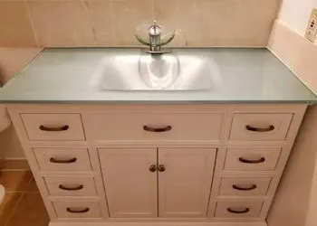 A bathroom vanity with a sink and drawers.