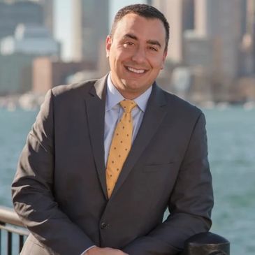 A man in a suit and tie is standing next to a railing.