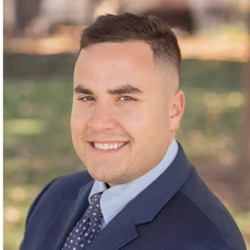 A man in a suit and tie is smiling for the camera.