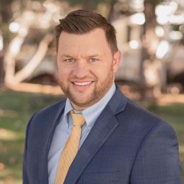 A man in a suit and tie is smiling for the camera.