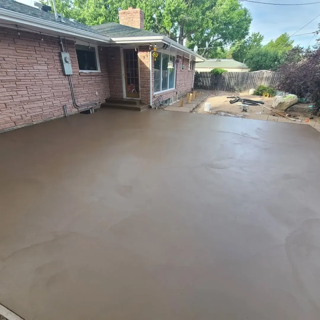 A brick house with a concrete driveway in front of it.