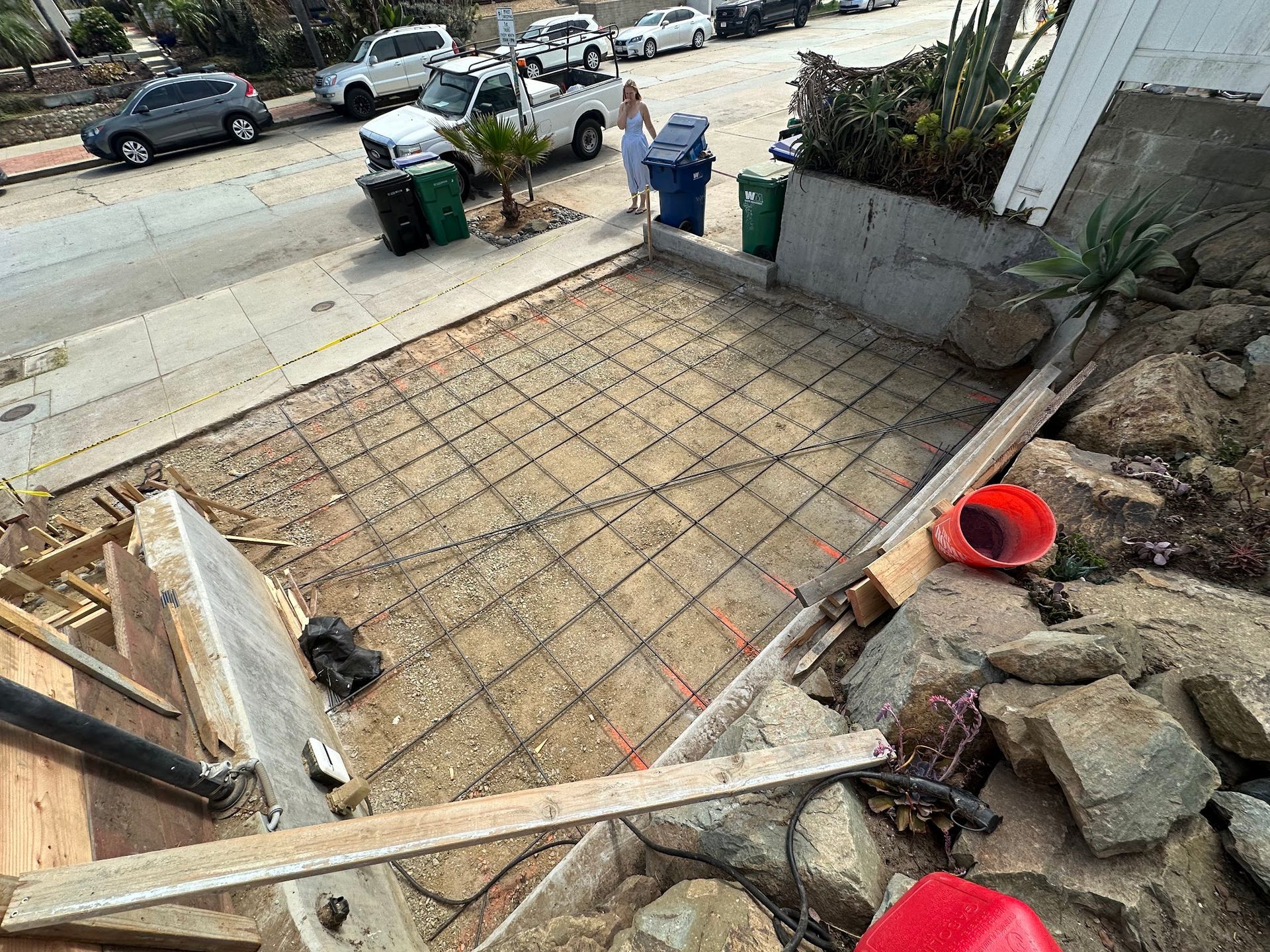 A concrete walkway is being built on the side of the road