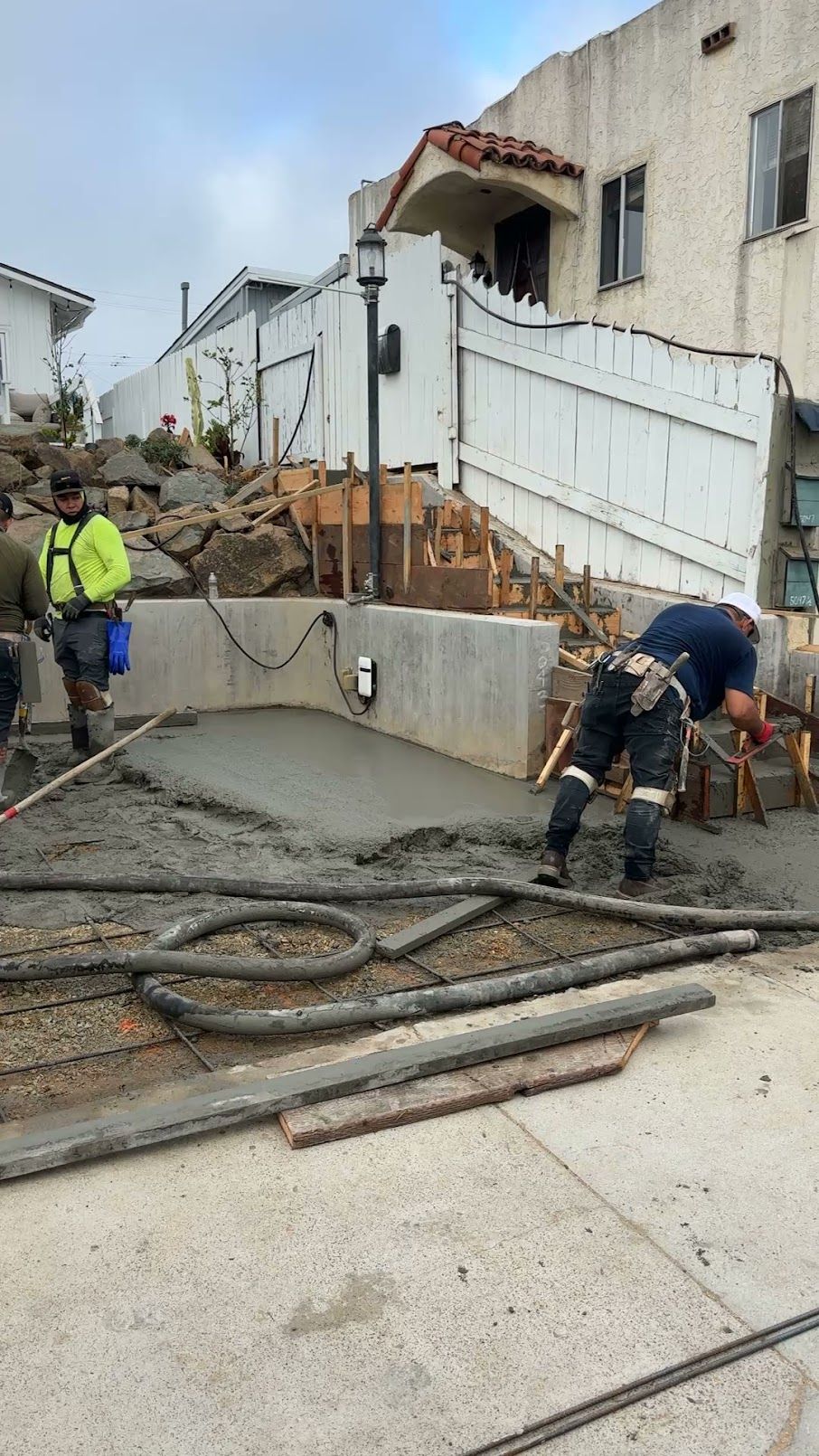 A brick driveway leading to a house surrounded by bushes and trees.