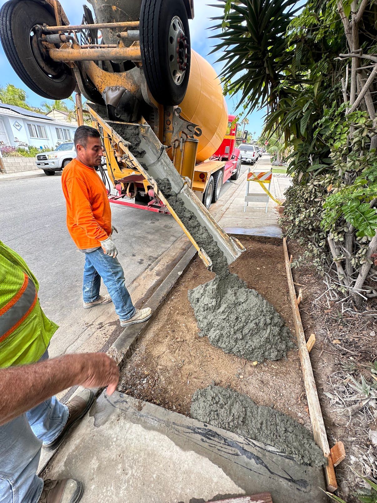 A concrete walkway is being built on the side of the road