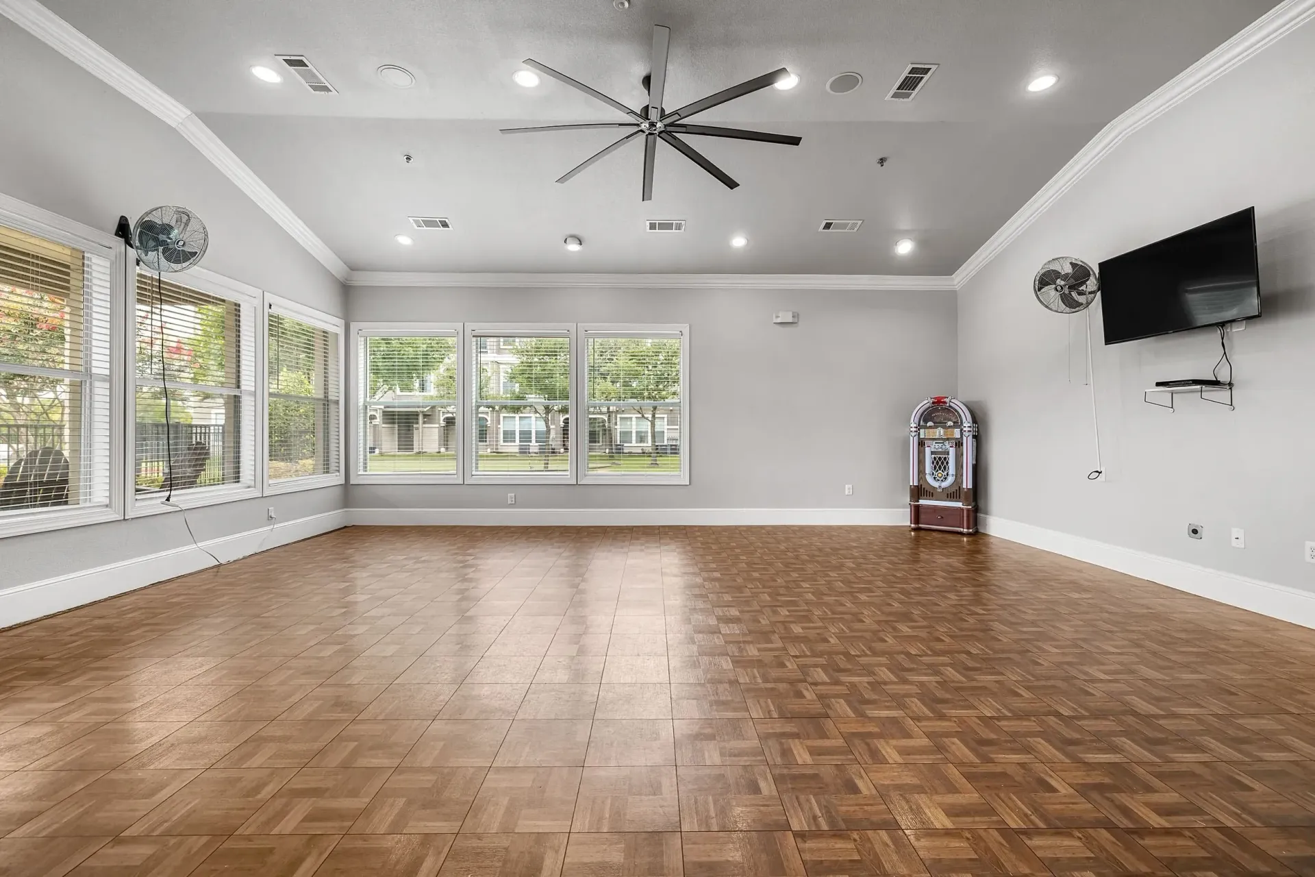 Community room with a large ceiling fan, jukebox, and TV.