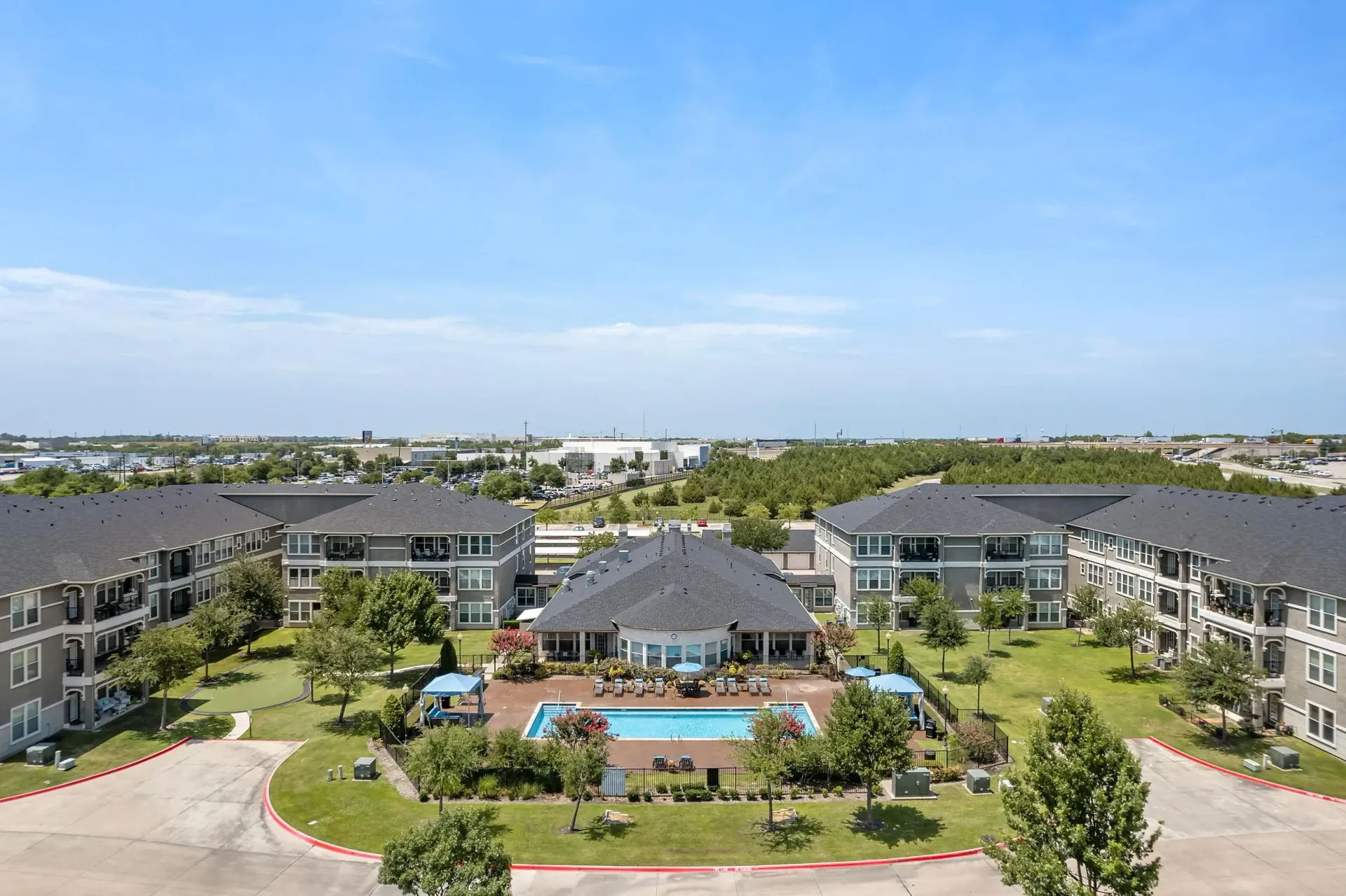 Apartment complex with an outdoor swimming pool and surrounding buildings.