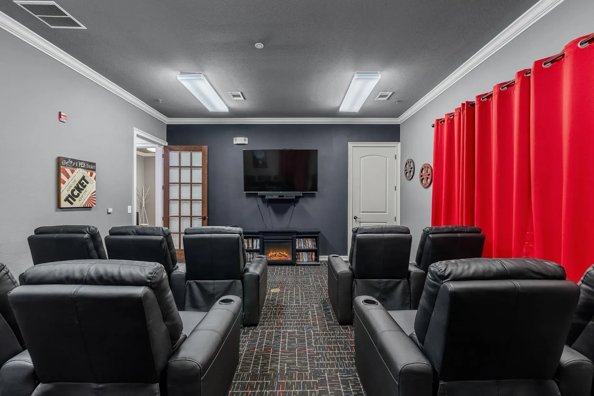 Community movie theater with plush recliners and large screen.