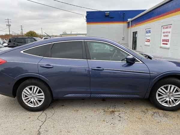 A blue car is parked in front of a building.