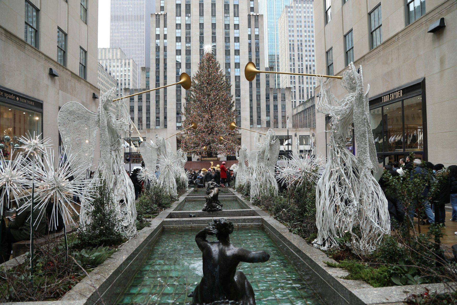 Christmas decorations at Rockefeller Center, New York City. Lit Christmas tree, fountains, and angel statues.
