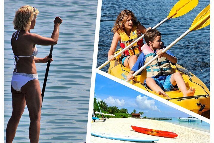 Woman paddleboards, family kayaks, beach scene with paddleboards and kayak on shore.