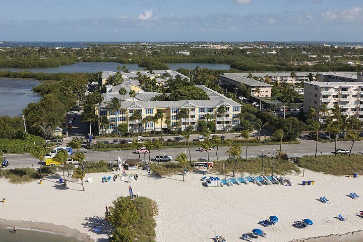 Aerial view: beach, ocean, multi-story buildings, trees, cars. Key West, Florida.