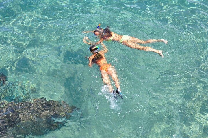 Two people snorkeling in clear blue water.