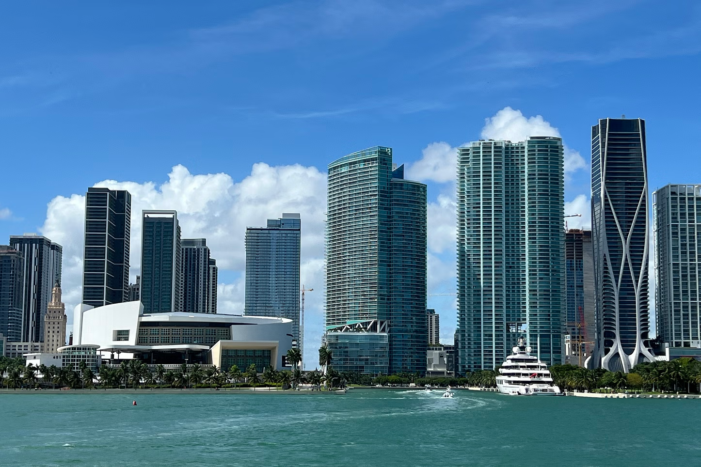 Miami skyline, turquoise water, skyscrapers, and a bright blue sky.