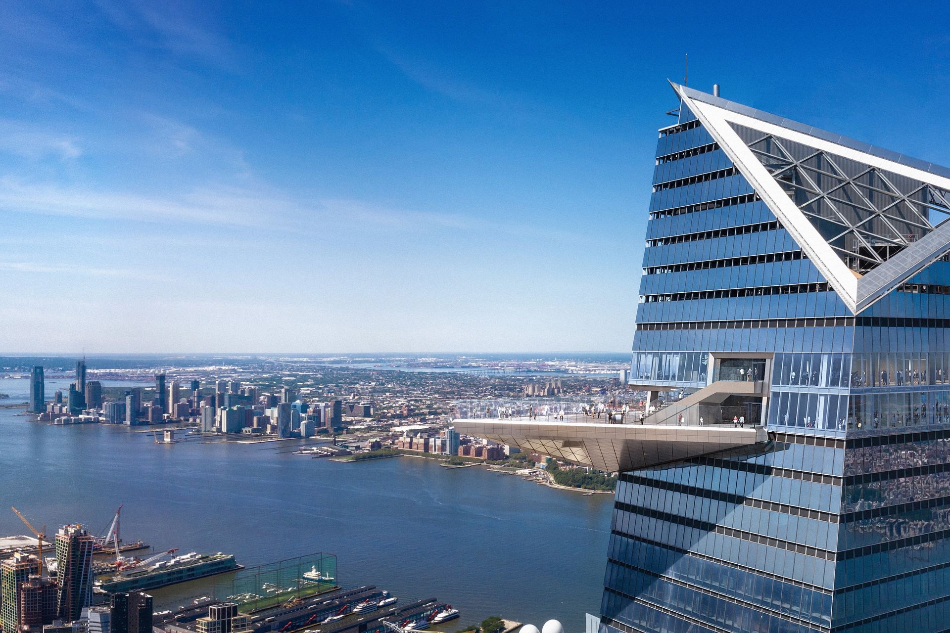 Aerial view of the Edge observation deck jutting from a skyscraper. New York City skyline and Hudson River in background.