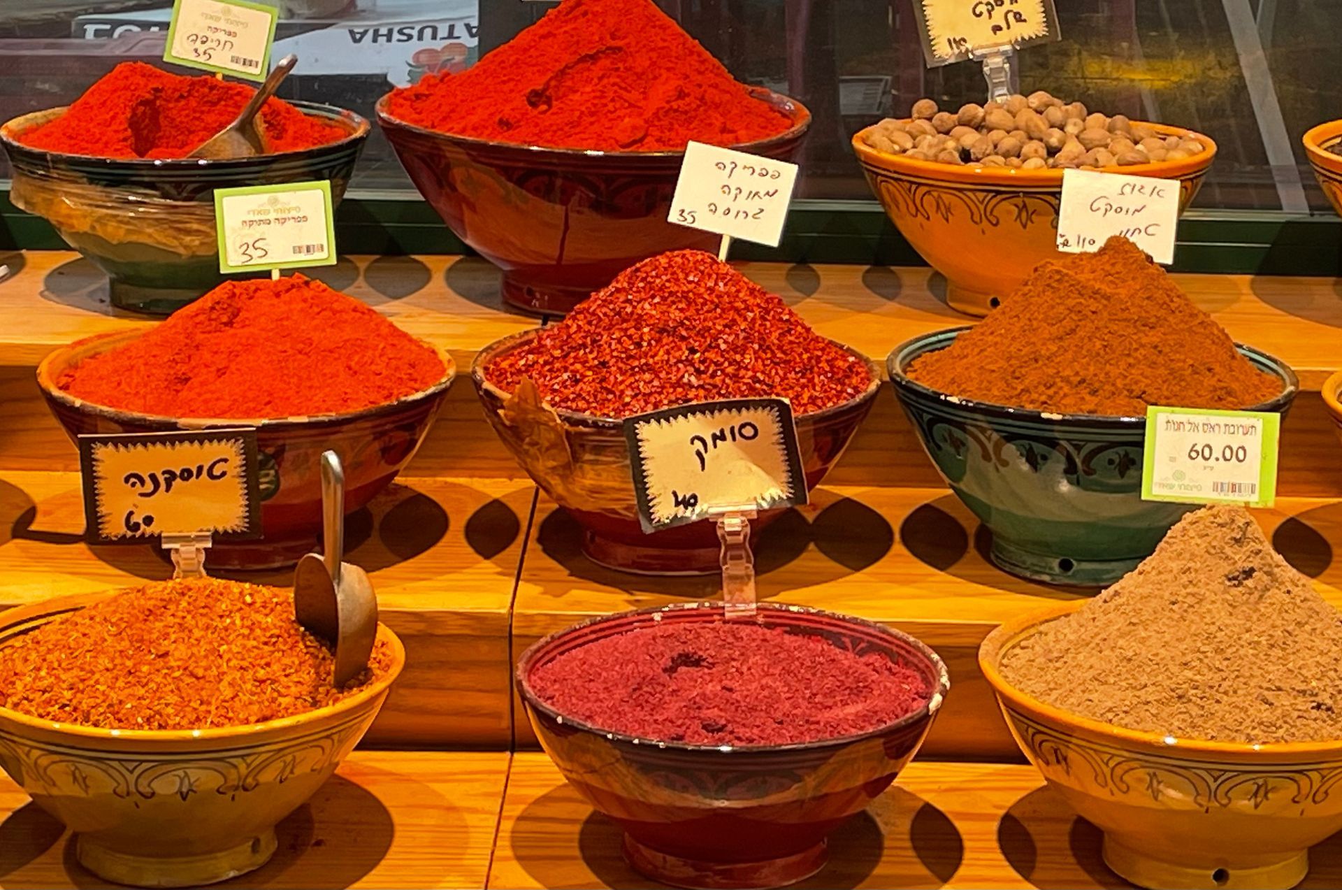 Bowls of colorful spices on display at a market stall.