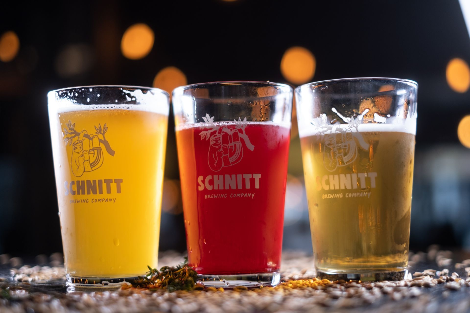 Three glasses of beer in yellow, red, and light yellow colors, with the 
