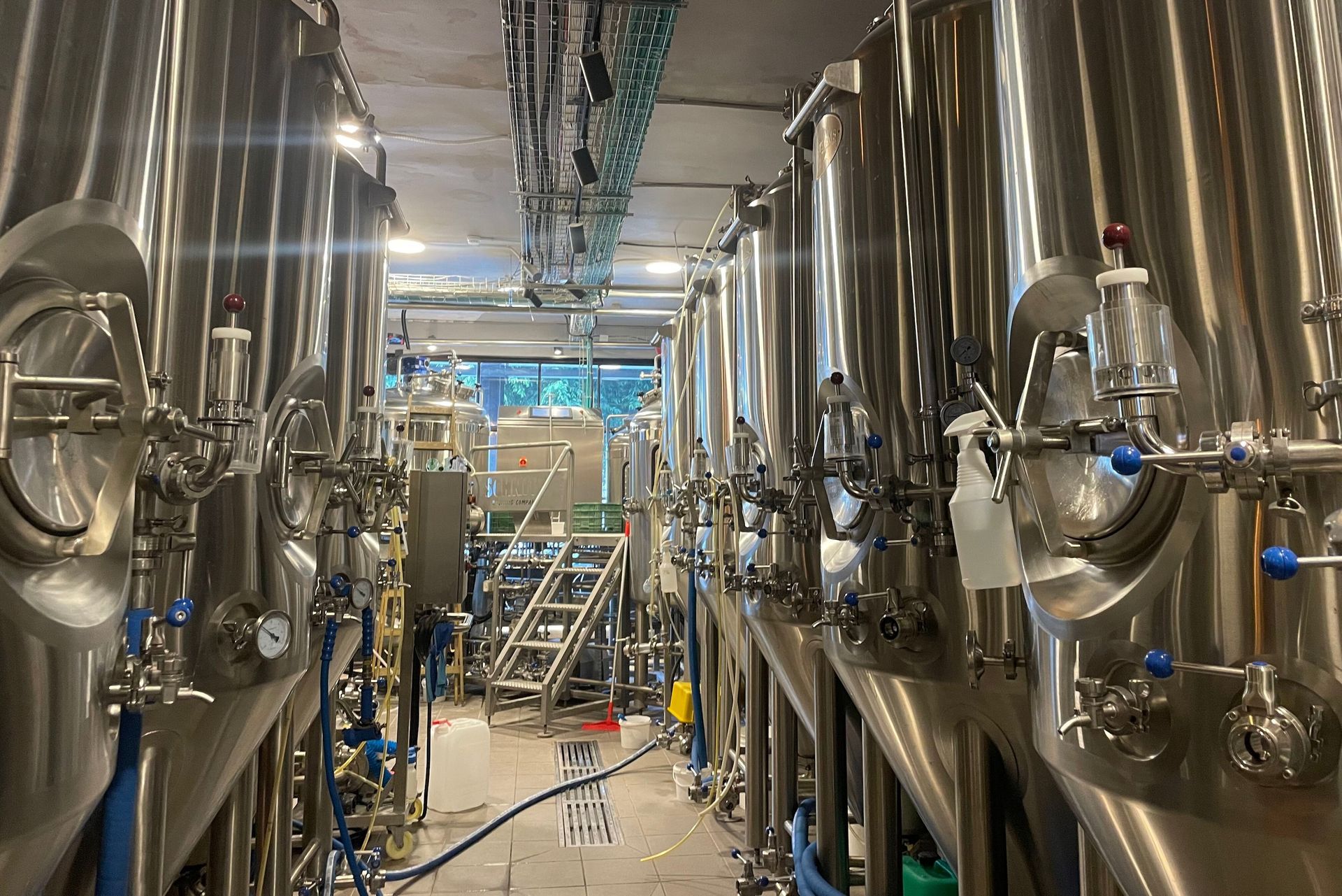 Brewery interior with stainless steel tanks and equipment.
