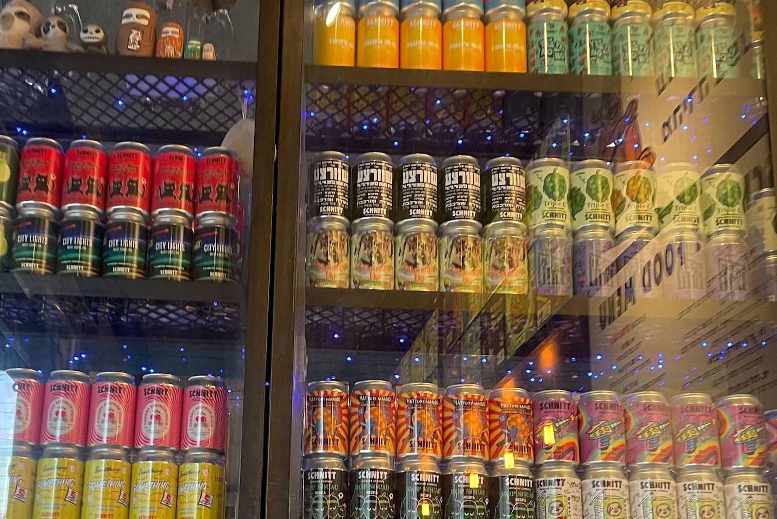 A display of colorful cans and jars on shelves, inside a shop.