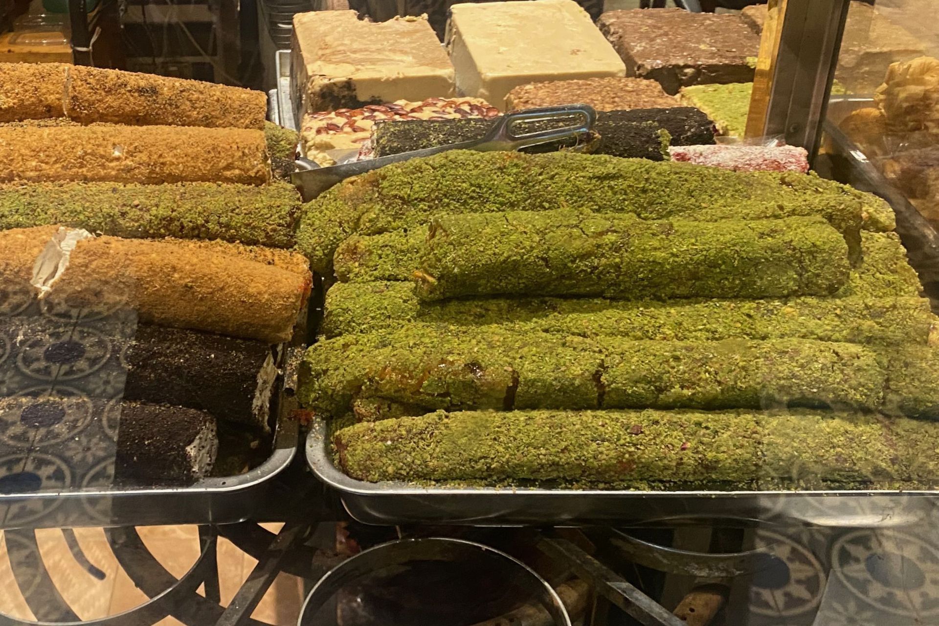 Display of Turkish delight in various colors and flavors, some dusted with pistachios.