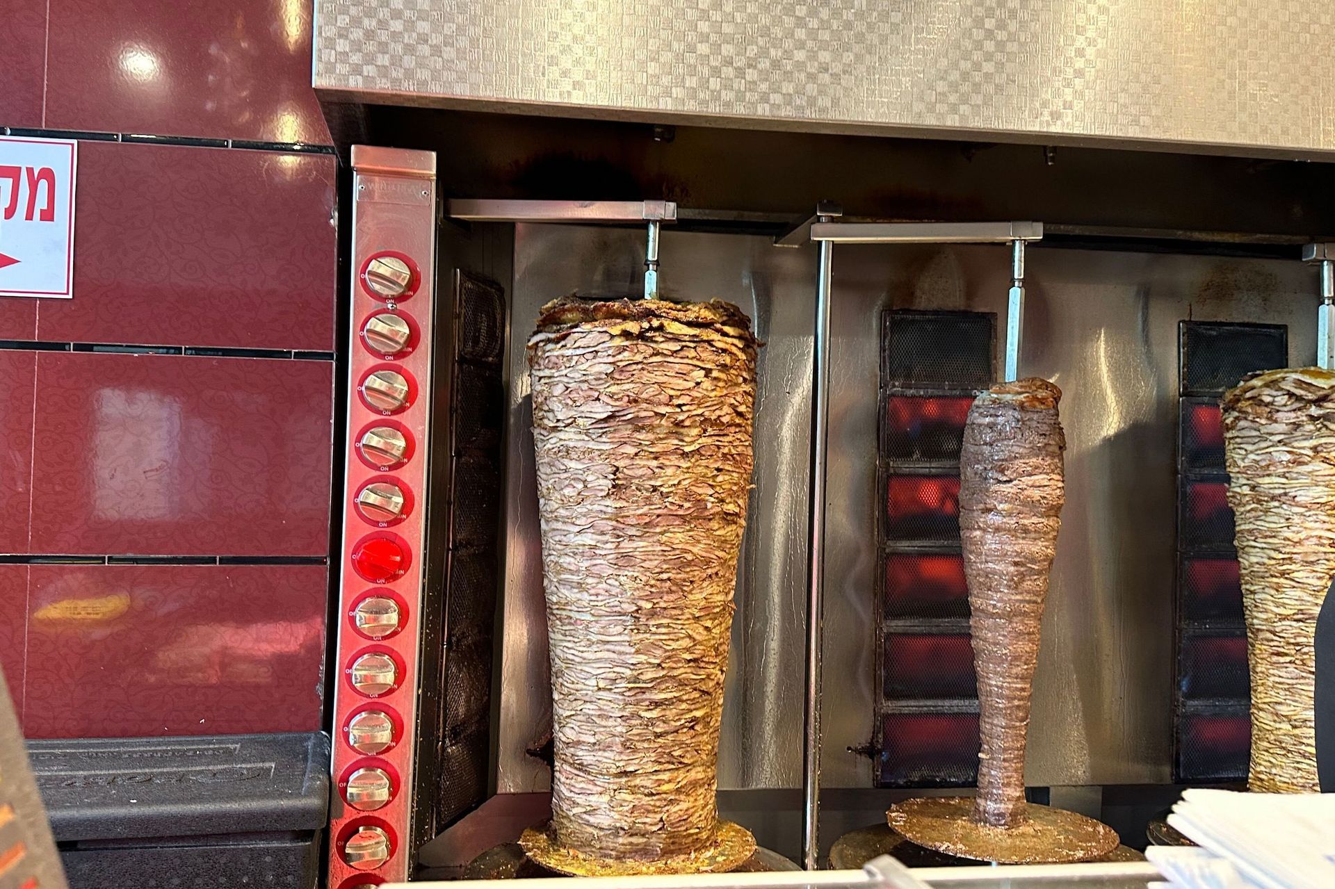 Shawarma spits with cooking meat in a restaurant, ready for slicing.