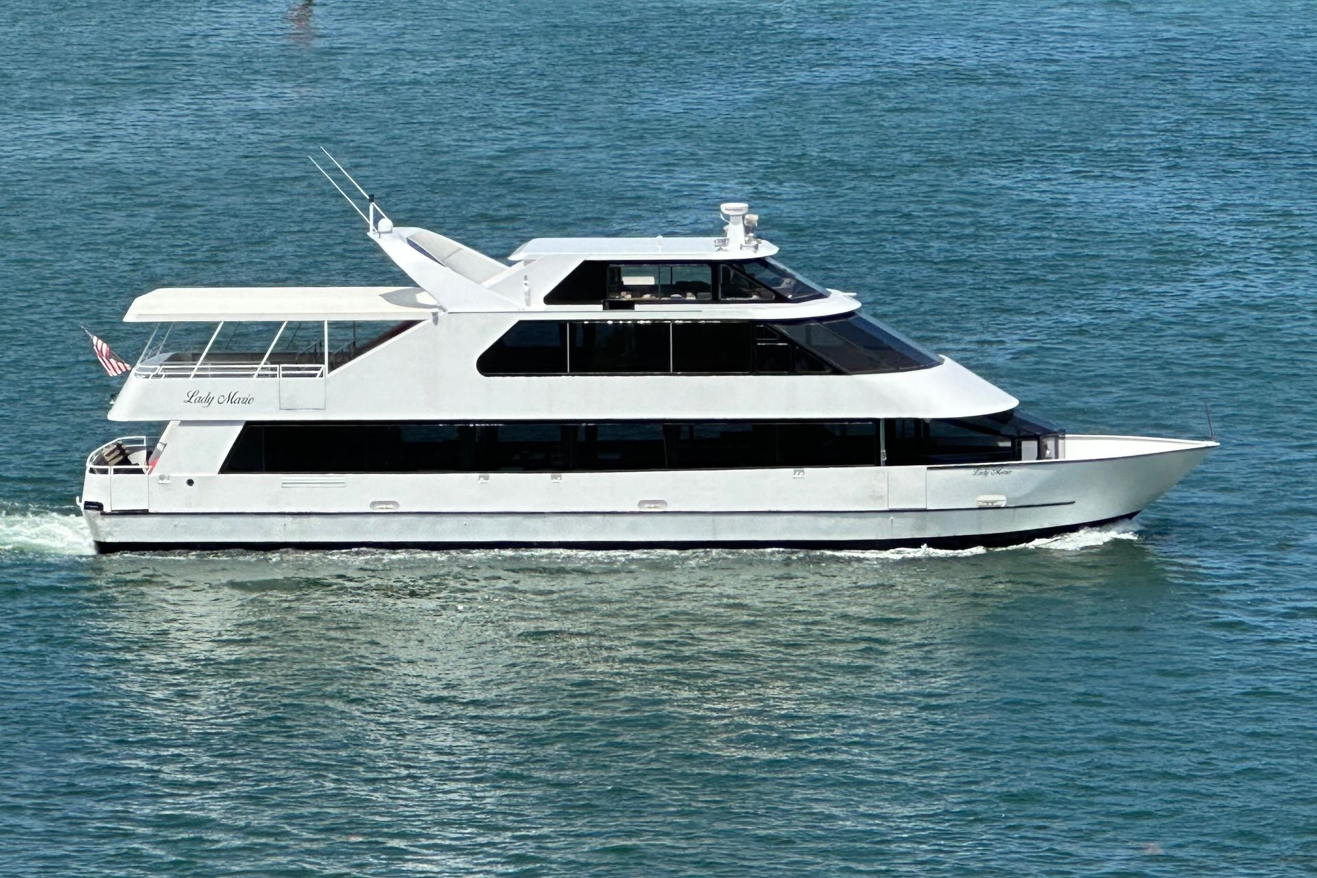 White yacht sailing on blue water.