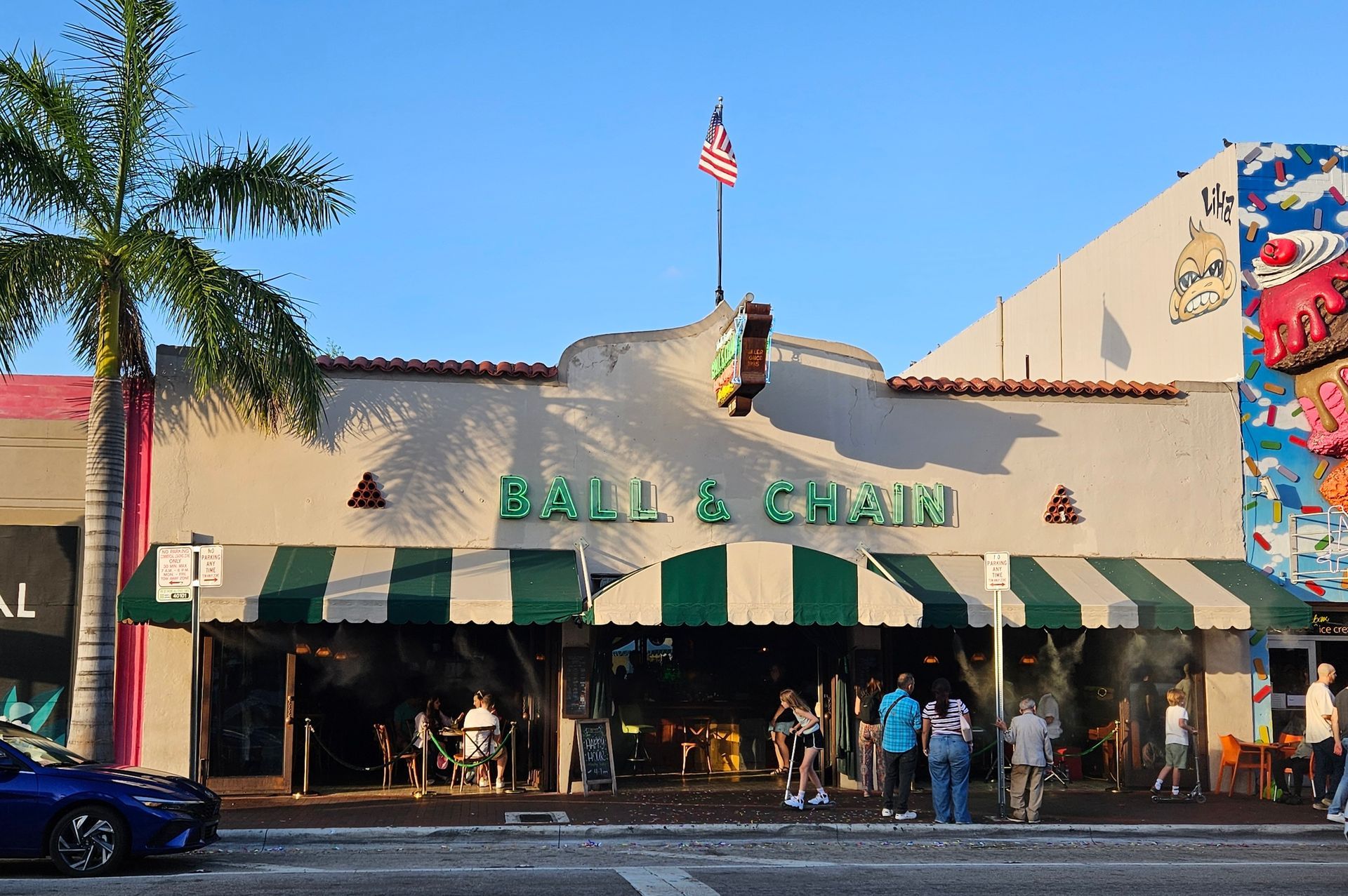 Ball & Chain bar in Miami with a green and white awning; people outside.