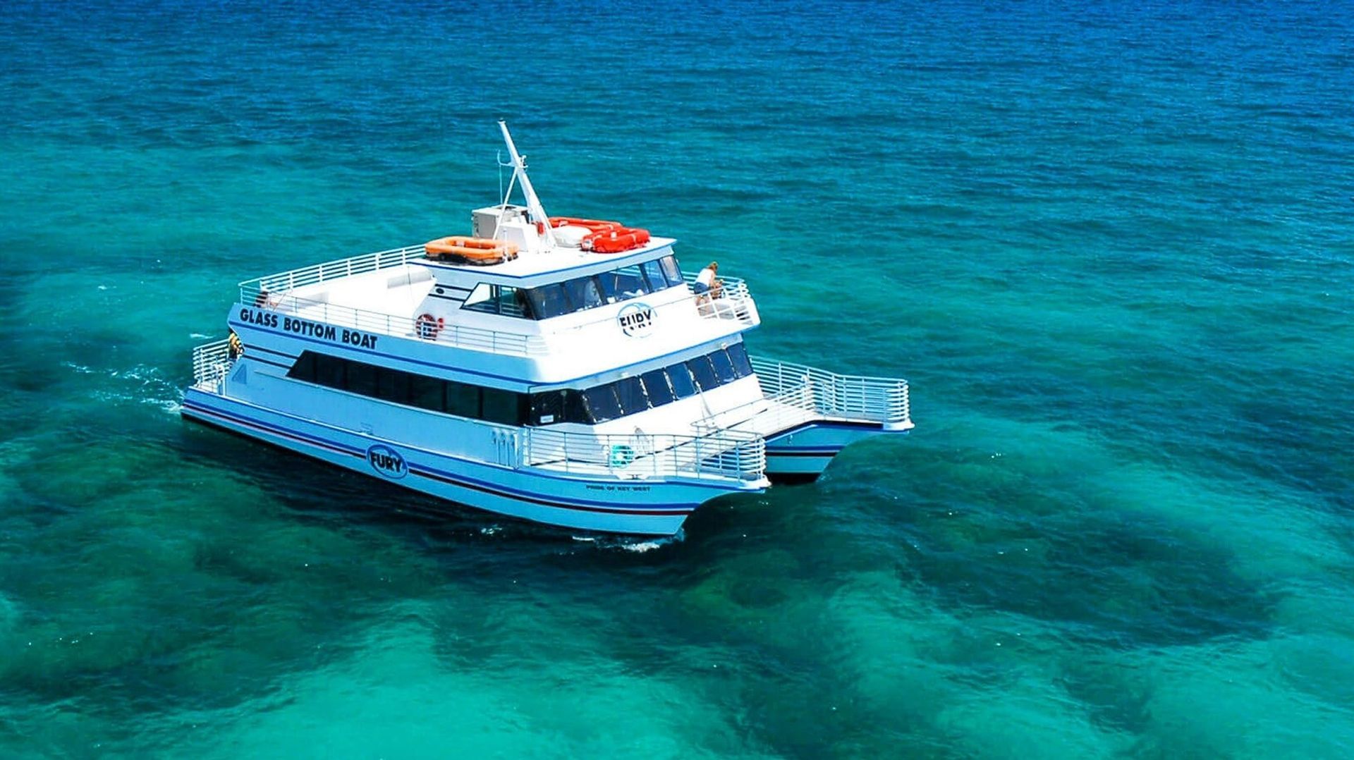 White catamaran boat on clear turquoise water.