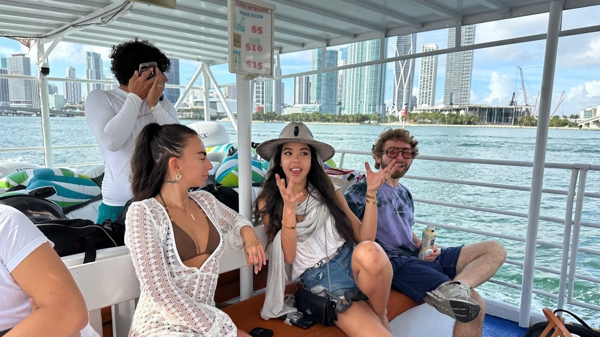 People on a boat with a city skyline in the background. They appear happy and relaxed.