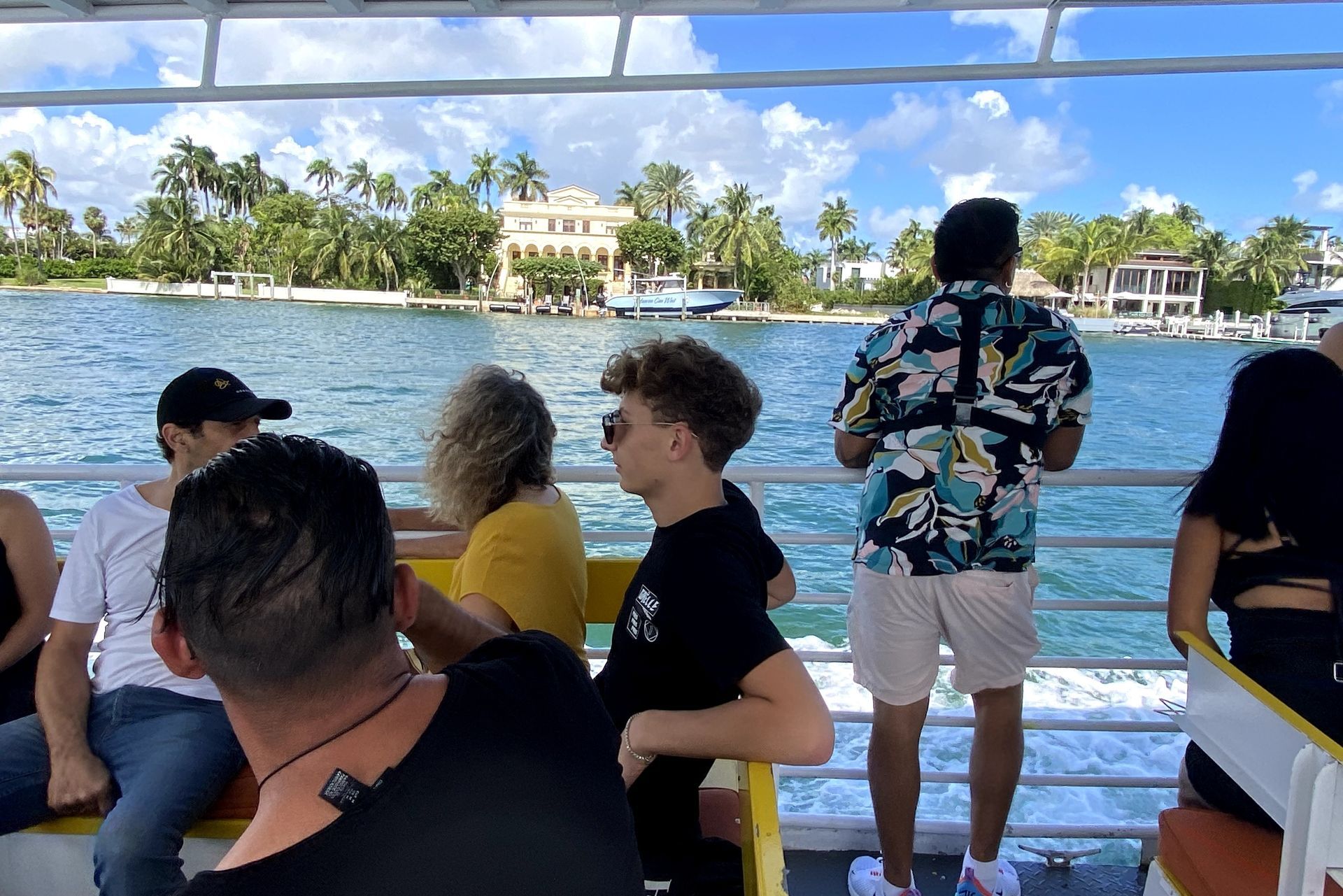 People on a boat tour looking at waterfront mansions in Miami.
