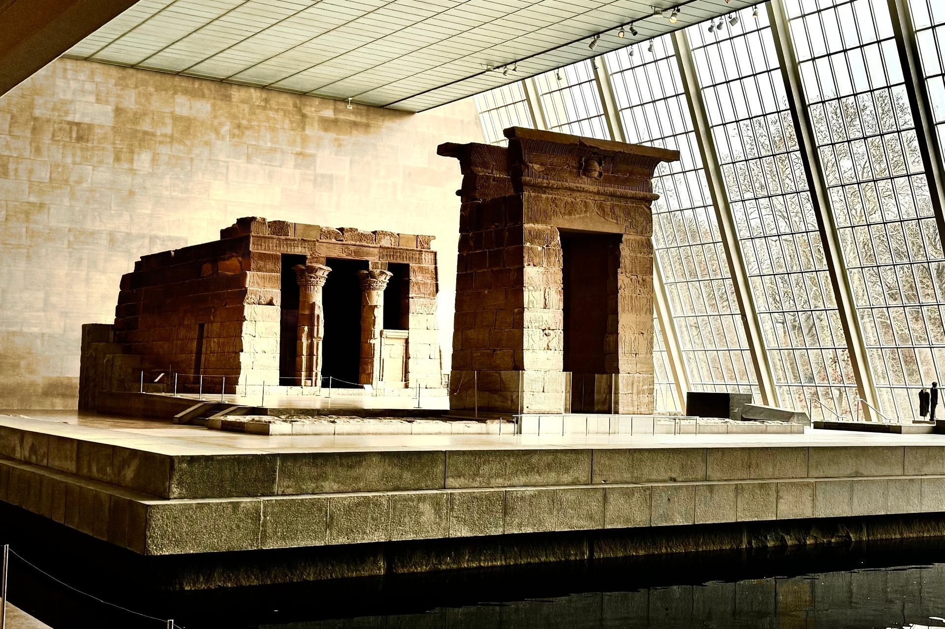 Temple of Dendur in the Metropolitan Museum of Art, New York. Ancient Egyptian stone temple with glass background.