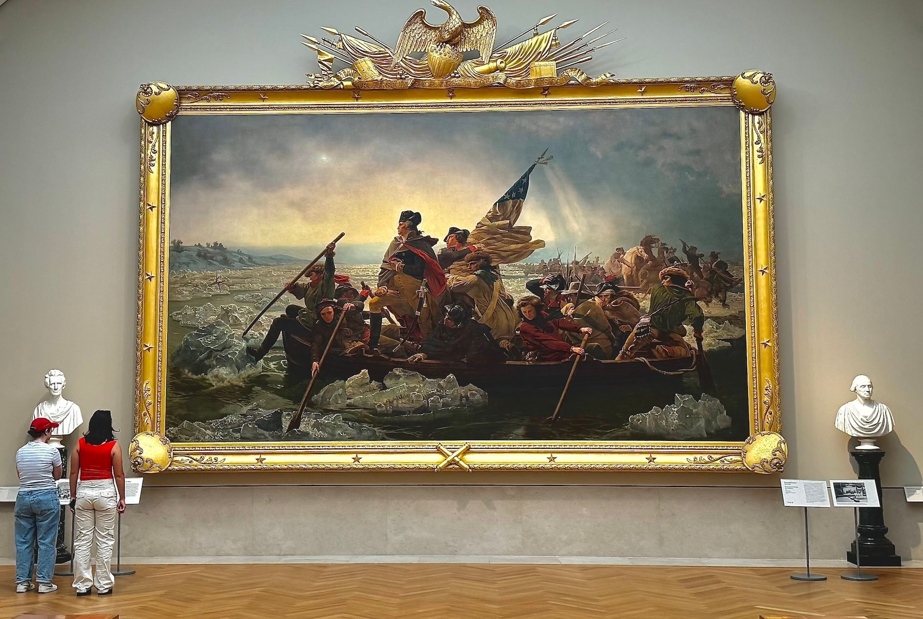 George Washington crossing the Delaware River painting in a museum, framed with spectators.