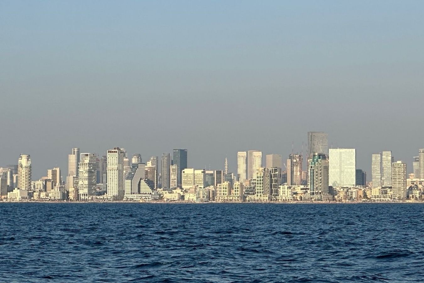 City skyline along a body of water under a clear sky.