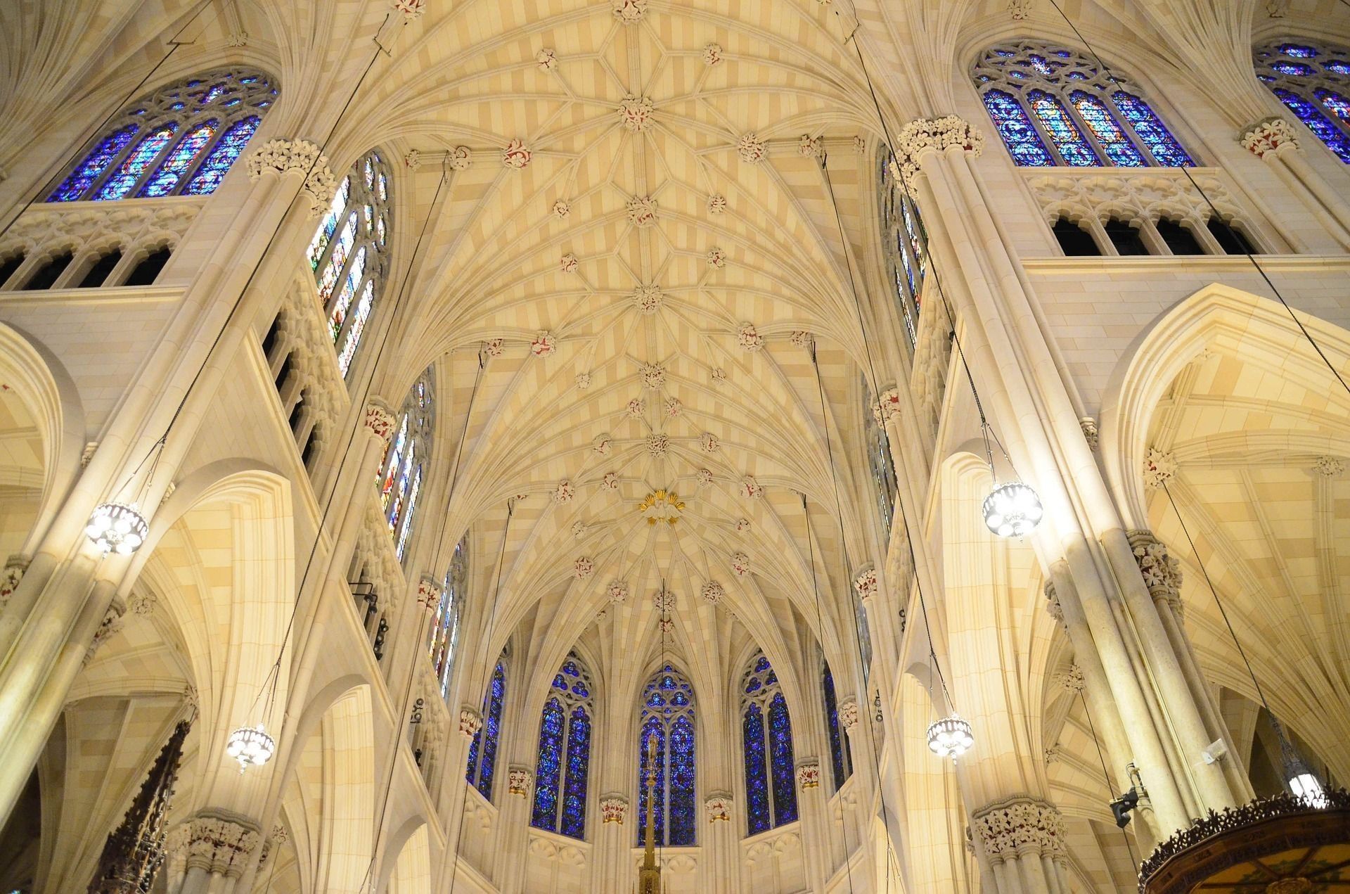 Cathedral ceiling with pointed arches, stained glass windows, and ornate stonework.