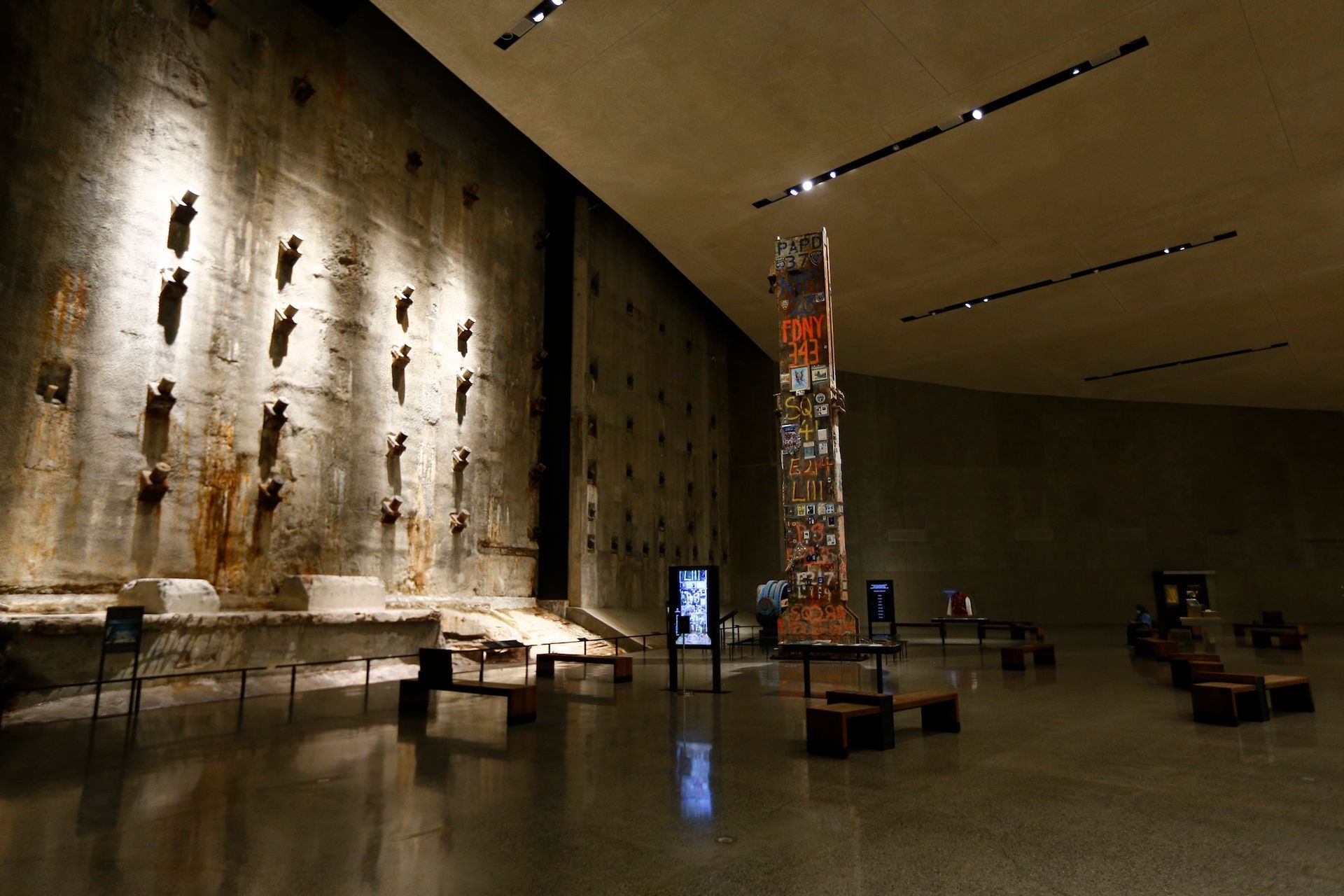 Inside the 9/11 Memorial Museum, a large exhibit hall with remnants of the Twin Towers and exhibits.