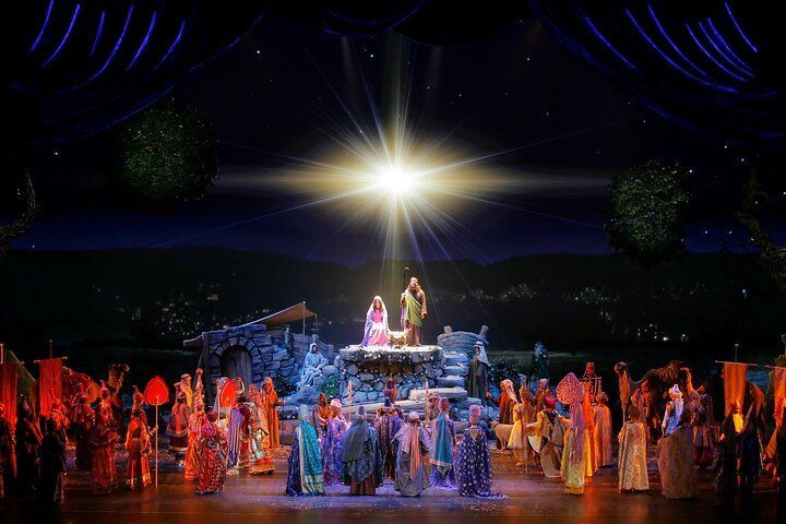 Nativity scene with bright star; Mary, Joseph, baby Jesus, and figures in robes.