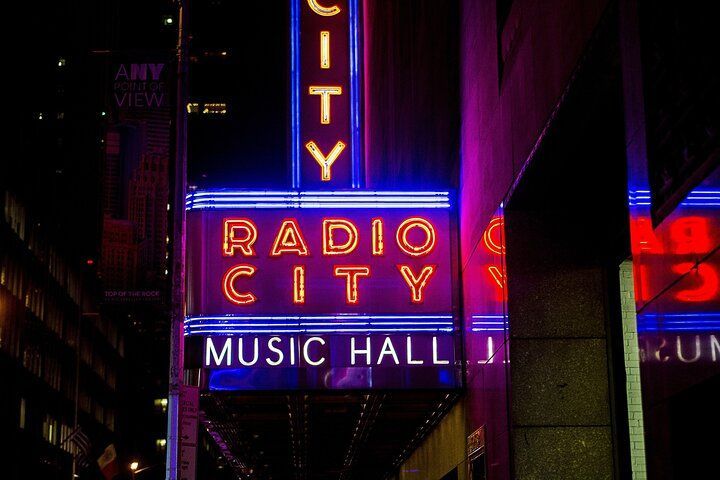 Radio City Music Hall neon sign at night, blue and red lights.