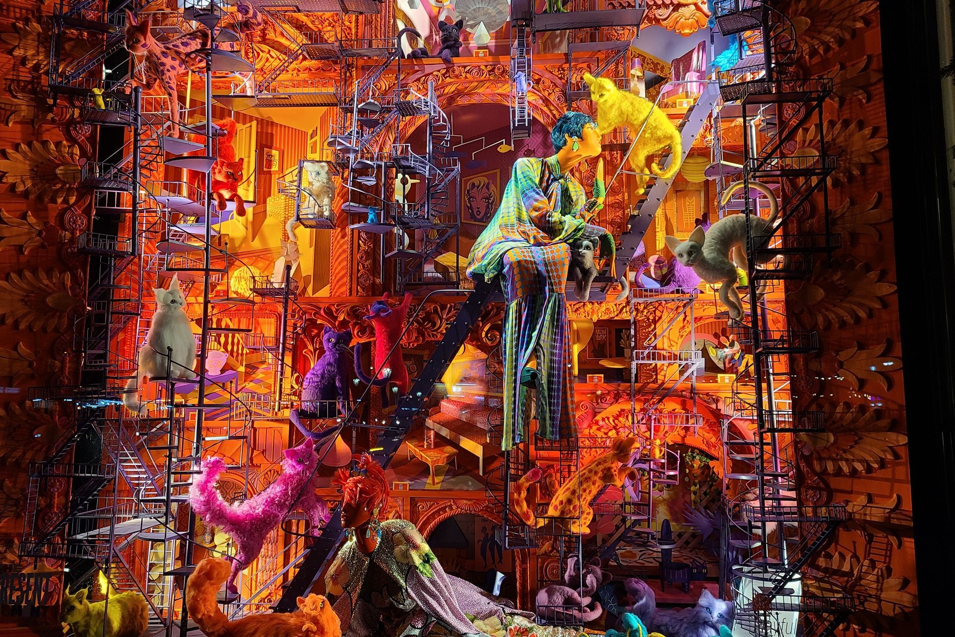 A colorful window display with fantastical creatures and elaborate architecture in warm tones.
