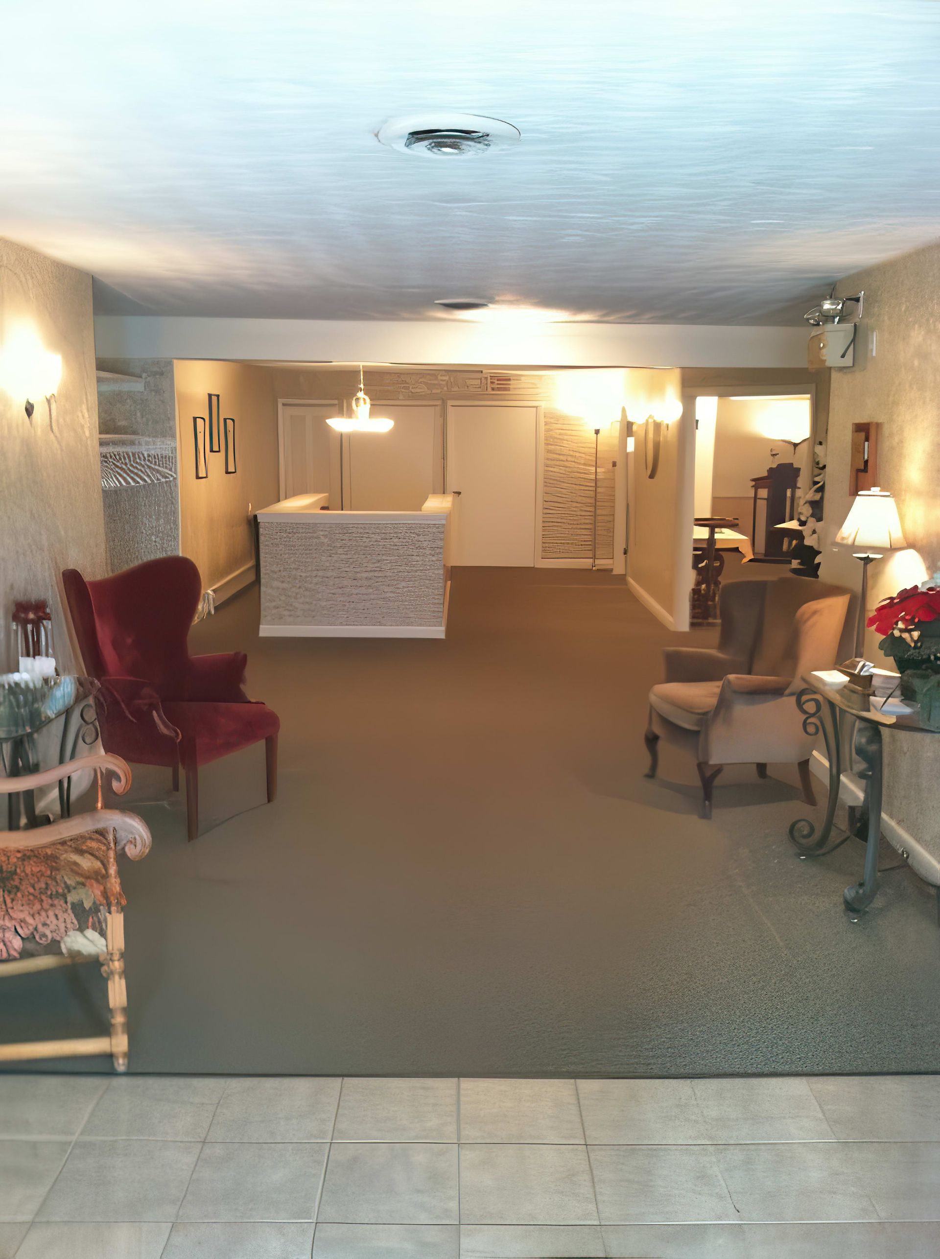 Reception area with chairs, muted colors, and a central desk.