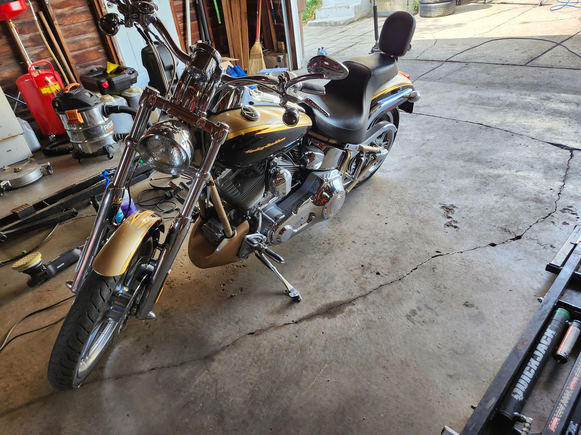 A black and gold motorcycle is parked in a garage.