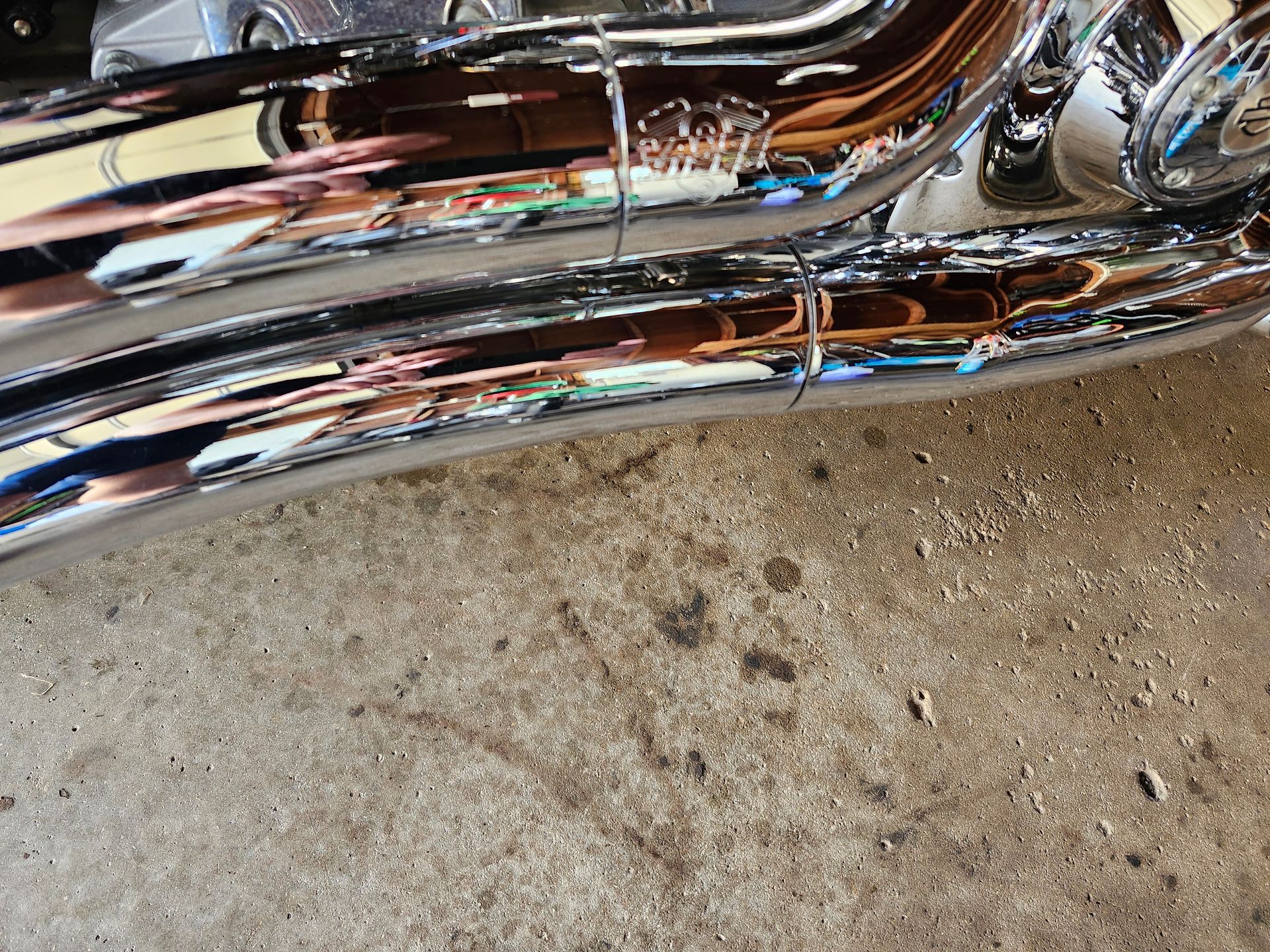 A close up of a motorcycle exhaust pipe on the ground.