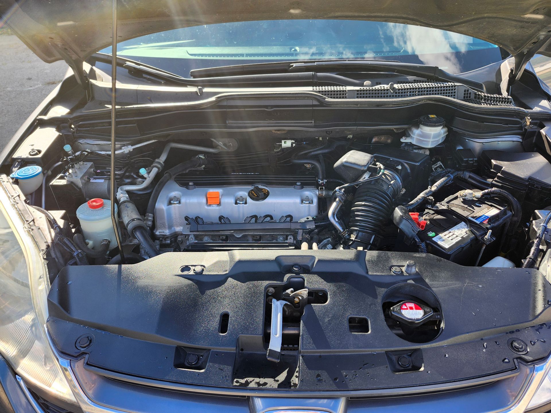 The engine of a car is shown with the hood open.