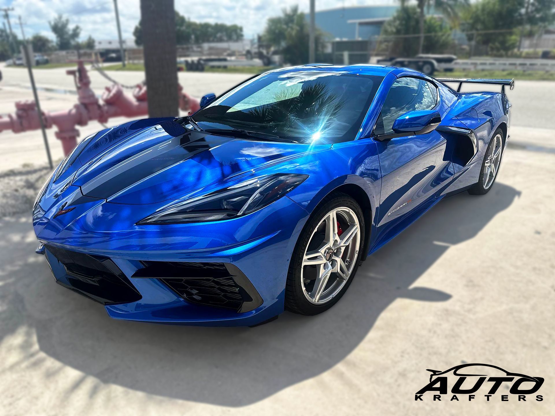 Blue Chevrolet Corvette sports car parked on pavement.