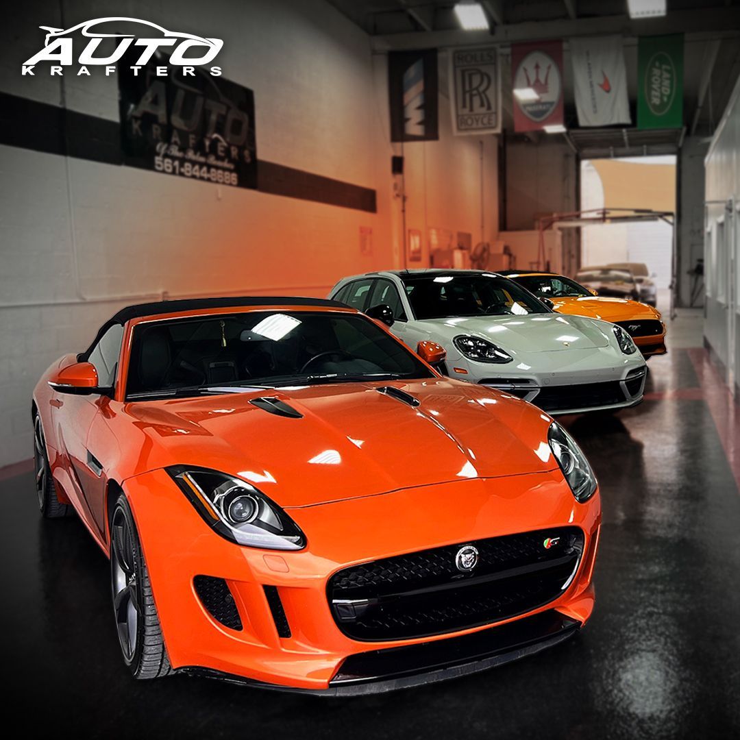 Red Ford Mustang parked in a garage, with a silver car visible in the background.