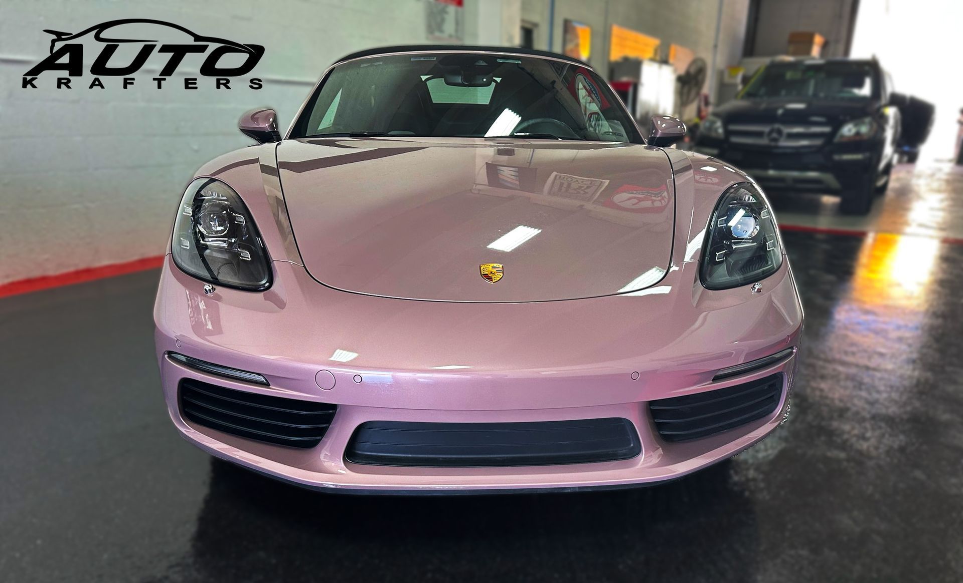 Pink Porsche sports car parked inside a garage.