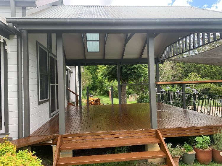 A Wooden Deck With Stairs Leading to It is in Front of a House — Holster Painting Contractors In Port Macquarie, NSW