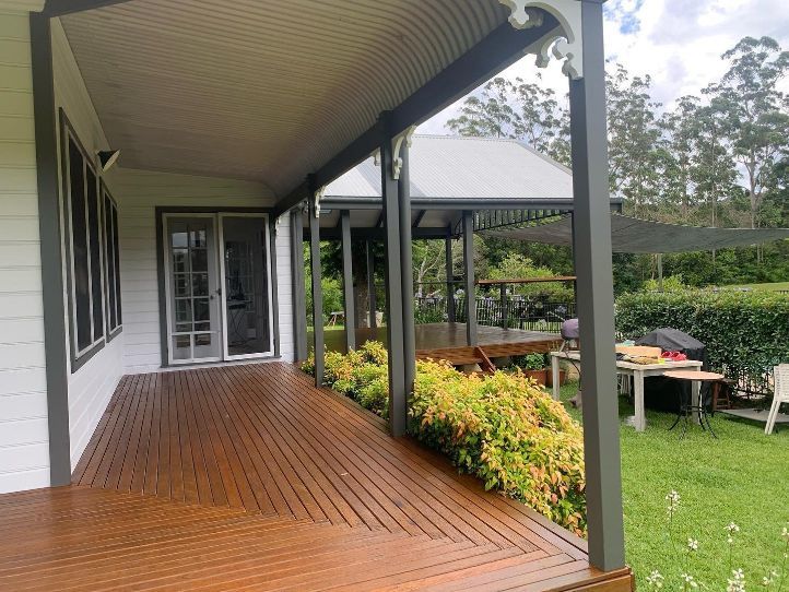 A Porch With a Wooden Deck and a White House in the Background — Holster Painting Contractors In Port Macquarie, NSW